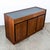 Compact walnut credenza with a black laminate top by Dillingham. This piece includes 3 drawers and 3 doors. A clean and...