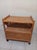 Vintage boho chic rattan and wicker bar cart with a dual-shelf design, a bottom enclosed cabinet with double doors, and...