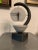 A vintage postmodern textured marble like stone clock shaped like a pendulum in a pedestal. It is signed and has a sticker...
