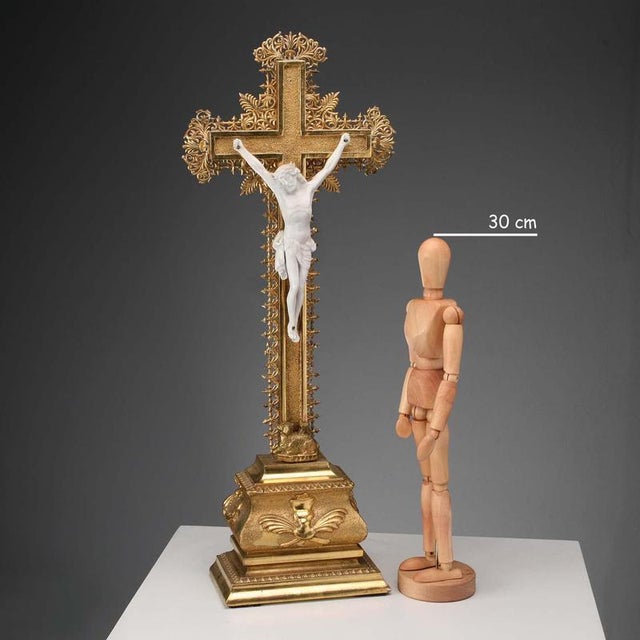Crucifix in gilded wood, engraved and finely pierced. Figure of Christ in biscuit porcelain. This piece is attributed to...