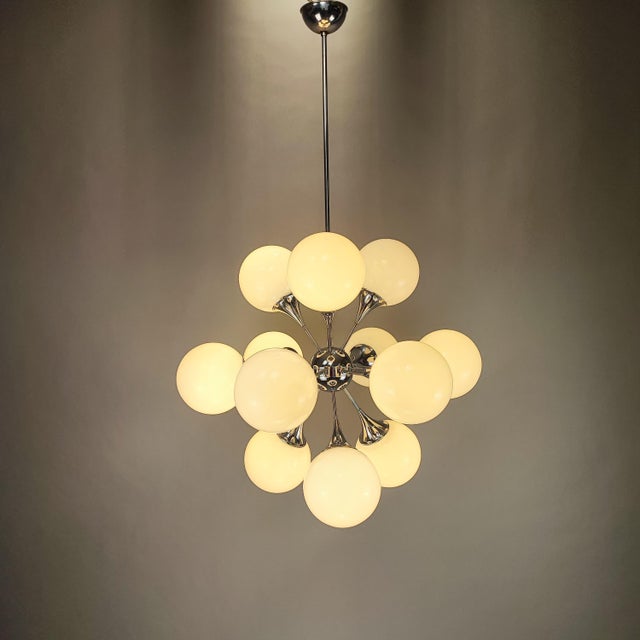 Sputnik pendant lamp with a 1960s space age design, produced by Reggiani. Chromed metal structure with 12 arms and 12...