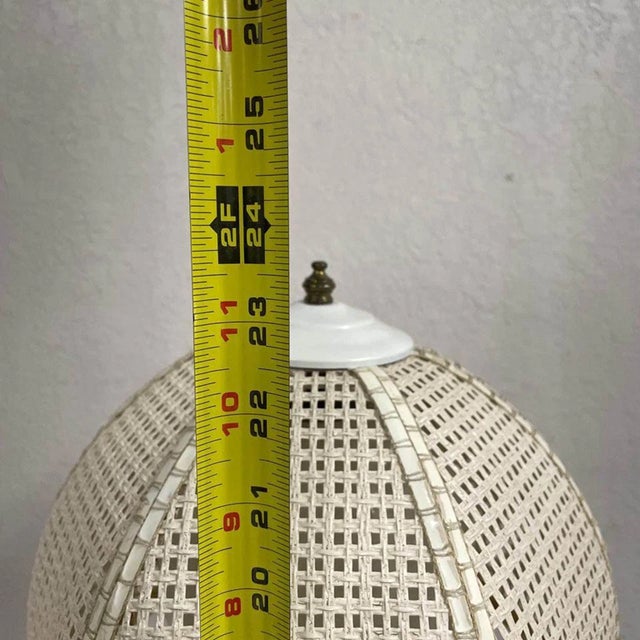 Stylish vintage Mid-Century Modern table lamp featuring a white faux bamboo base paired with a woven wicker shade and an...