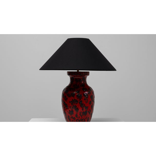 This 20th Century German red ceramic table lamp features a bold, sculptural presence defined by its vivid glaze and...