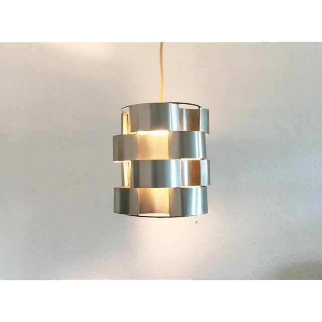 Curved aluminum sheets in a wire frame as a carrier. This materiality and processing characterize the luminaire designs by...