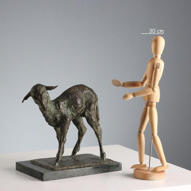 Bronze sculpture depicting a lamb on a marble base. Engraved signature of the artist. This piece is attributed to the...