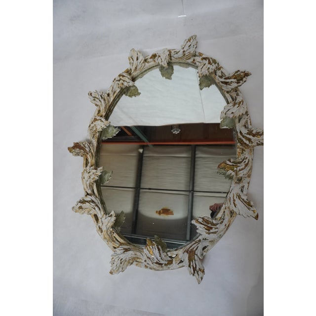 1930s Italian Painted Mirror With Leaves from MLA Italian oval-shaped mirror with leaves carved into the frame surrounding...