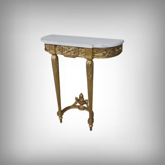 This small Louis XVI style giltwood console table displays an elegance where the white Carrara marble top contrasts with...