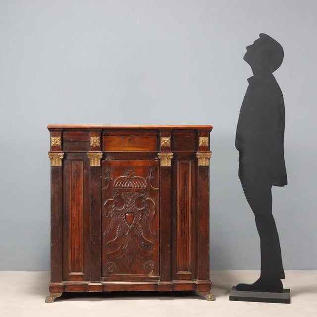 Walnut and fir sideboard. Antique central door with a carved crowned two-headed eagle, surmounted by a drawer, four column...