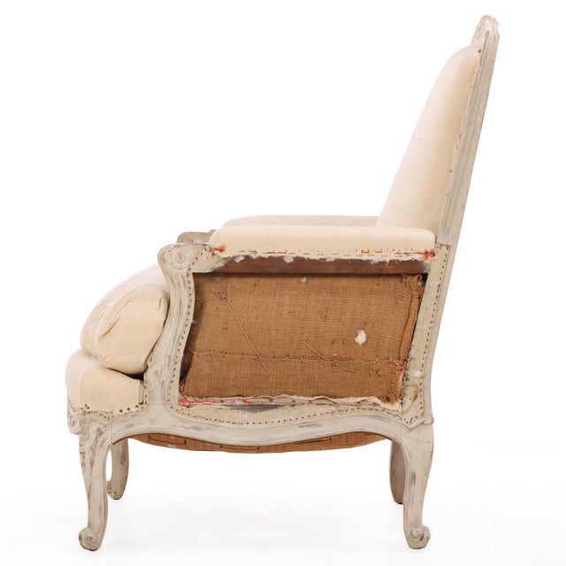 A fine pair of Louis XV style bergères, the carved cartouche-crested backs above padded closed arms and a shaped, foliate-...
