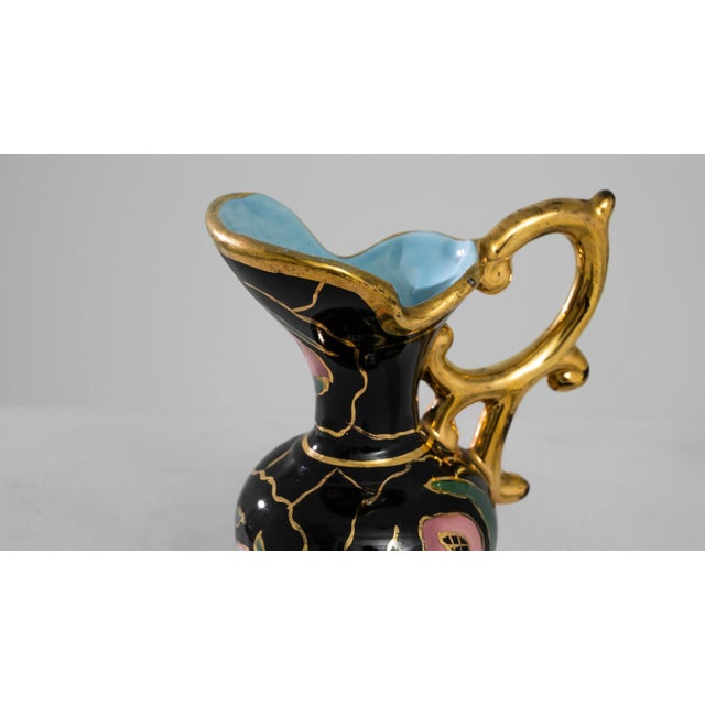 Behold the allure of this 1960s French ceramic jug, a paragon of elegance. Cloaked in a main black hue, it is adorned with...