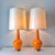 Vintage pair of Robert Abbey for Jonathan Adler large orange glass Capri table lamps. The lamps are shown with the...