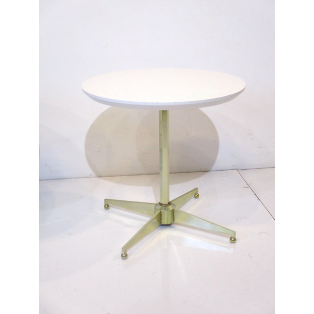 A pair of unique Mid Century white laminate topped side tables with brass octagon shaft and star bases having ball feet ....