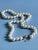 Vintage Mid Century single strand faux pearl necklace featuring bright white pearlized beads and an ornate silvertone...