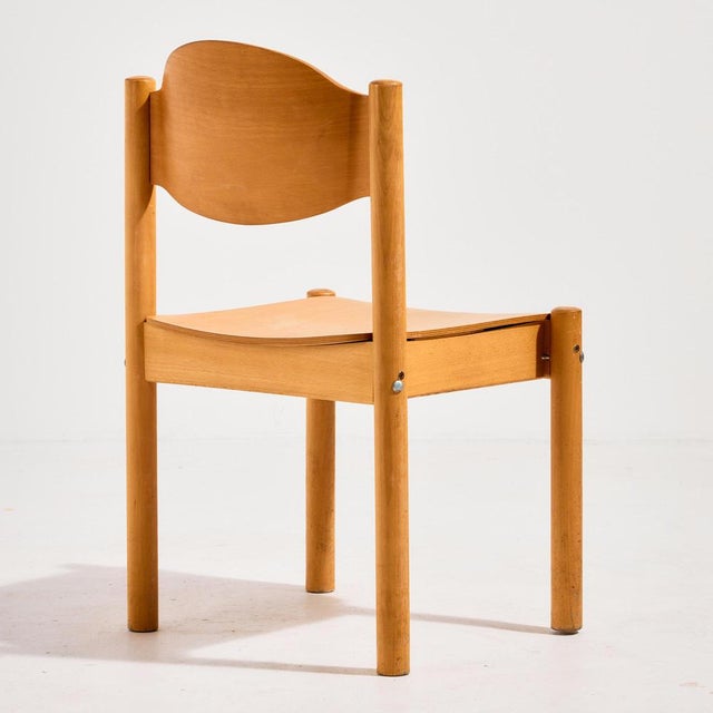 Stackable oak chair from the 1970s. The surface of the chair has scratches, stains and wear in places.
