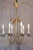 A French gilt metal six-light chandelier from the 20th century inspired by Maison Charles, with swoop arms and foliage...