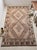 This vintage Afghan Maimana Ghalmori kilim is a large handwoven rug with a light beige center, warm brown borders, and...
