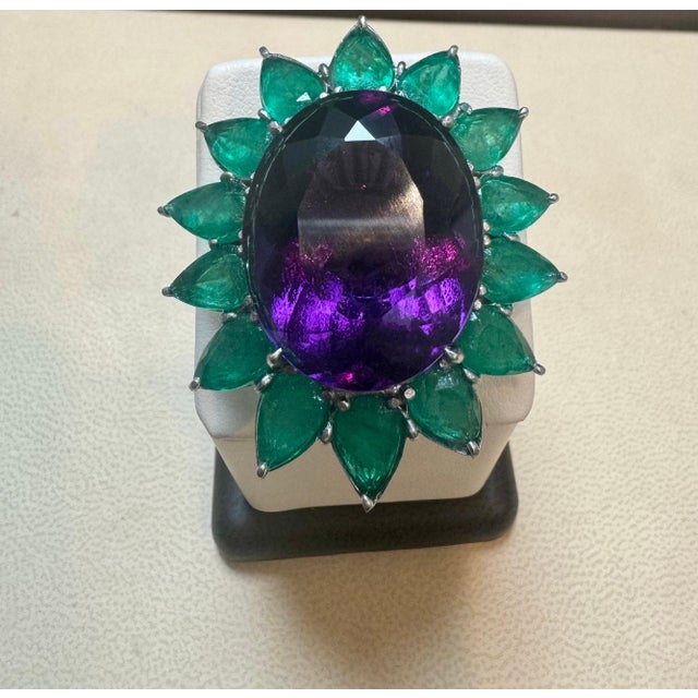 Approximately 30 Ct Oval Amethyst & 25 Ct Emerald Large Cocktail Ring in Platinum, 32 gm, Size 6. This beautiful cocktail...