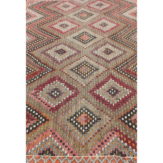 Measures: 6'5 x 10'2. This Turkish Embroidered Jajeem displays a repeating diamond pattern in the field and a simple zig-...