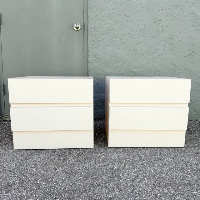 Chic pair of vintage Postmodern nightstands featuring a soft blush pink laminate finish and clean, minimalist styling....