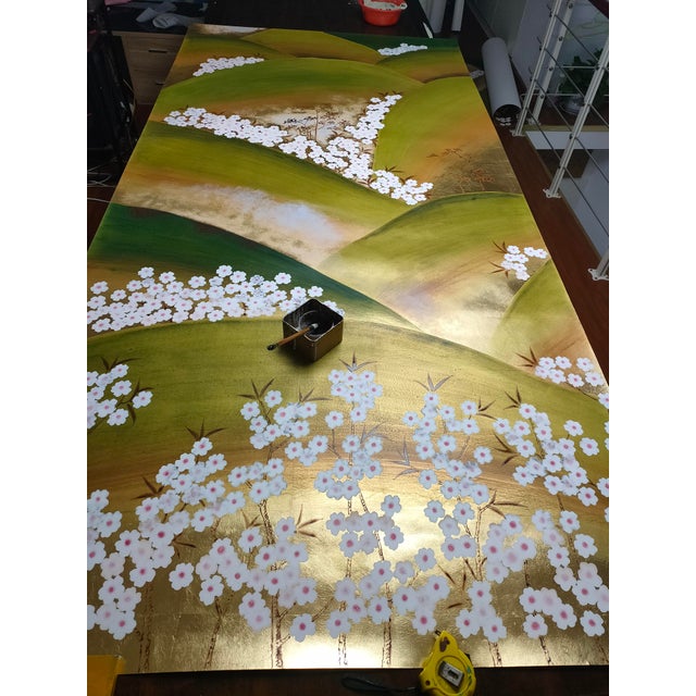A sophisticated hand-painted chinoiserie landscape mural featuring soft rolling mountain hills, delicate white cherry...