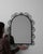 A 20th century French wall mirror constructed in wrought iron with a simple, structured frame. The iron surface retains a...