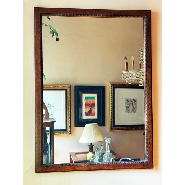 Early 20th century American Federal Revival wall mirror featuring a solid wood frame with a warm medium brown finish that...