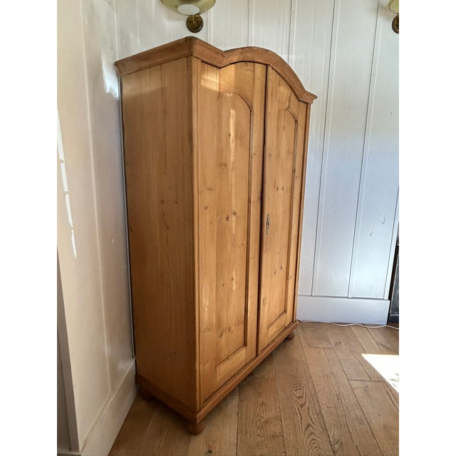 Vintage European pine armoire with newly added interior shelving and ball feet. Interior features solid wood shelves...