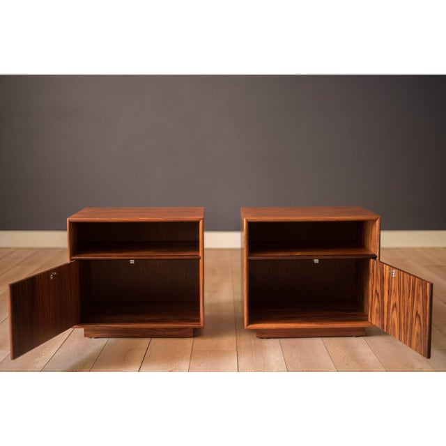 Vintage pair of nightstand end table cabinets in rosewood, made in Denmark circa 1970's. This set features natural rich...