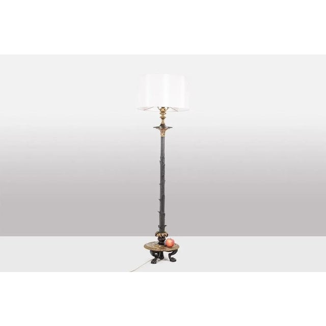 Restoration style floor lamp in bronze with two patinas, with plant decoration, the circular base. French work realized...