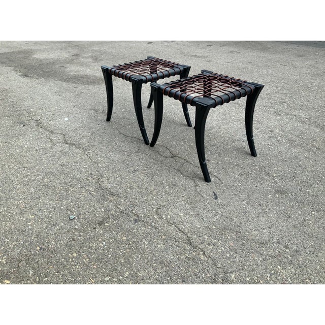 Modern Klismos style ottomans. Ottomans have a matte black finishwith round leather cording. The Ottos are in like new...