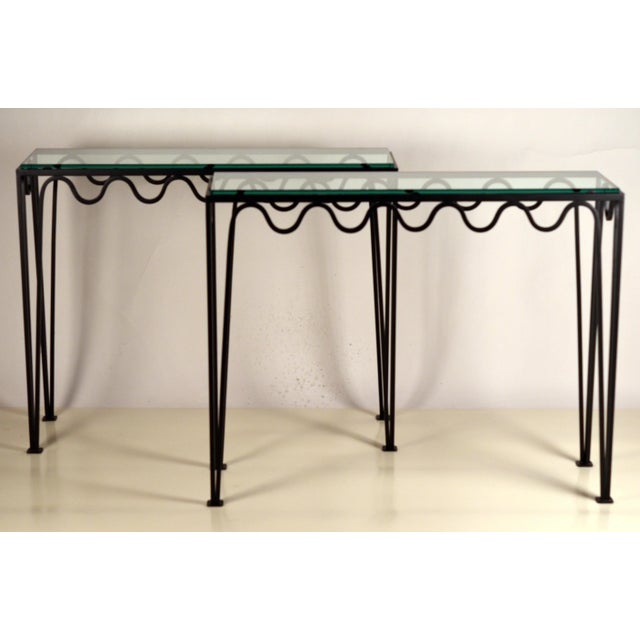 Pair of undulating matte blackened iron and glass consoles by Design Frères.