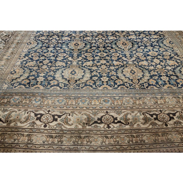 A finely-knotted late 19th century Persian Mashad rug, the midnight field with a trellis of palmettes, leafy flowering...