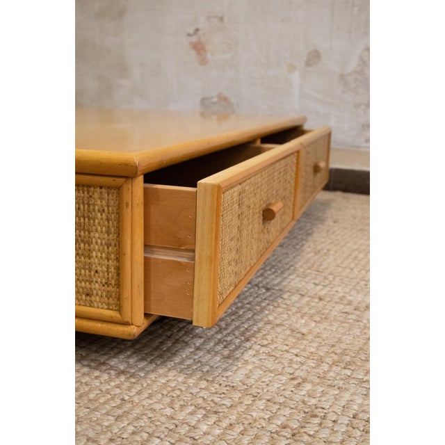 1970s low coffee table featuring a rectangular bamboo structure, smooth top and drawer fronts covered in woven rush....