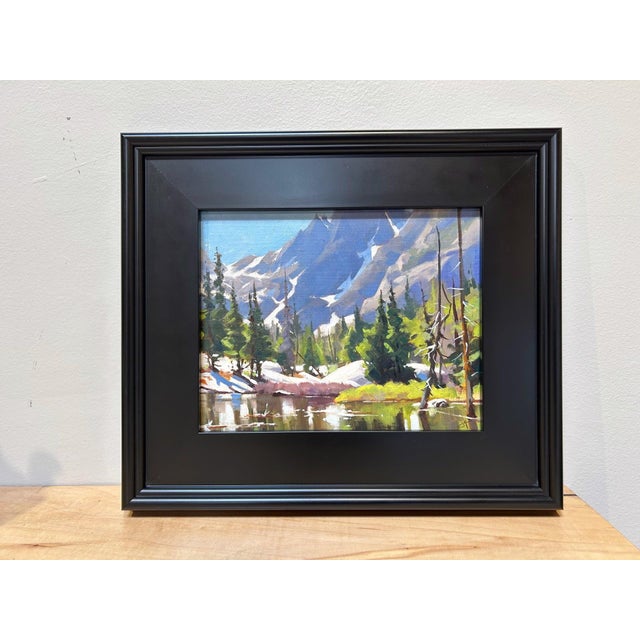 Dream Lake captures a serene alpine landscape, where towering mountains rise majestically in the background, their peaks...