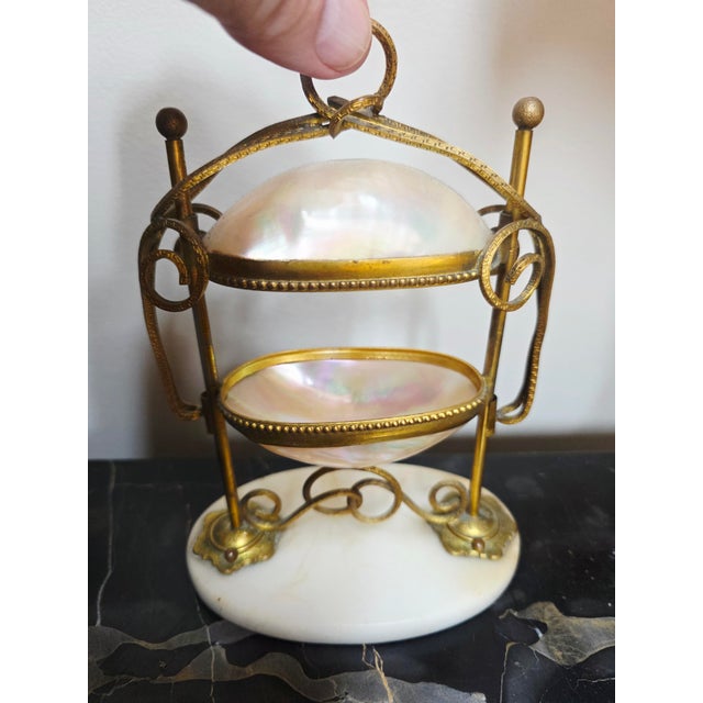 This is an antique French Palais Royal egg-shaped trinket box, often called a "casket".It is crafted from mother-of-pearl...