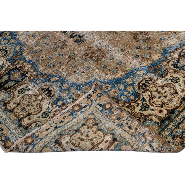 Beautiful vintage distressed medallion hand-knotted wool rug with a brown field. This rug has blue and tan accents in a...