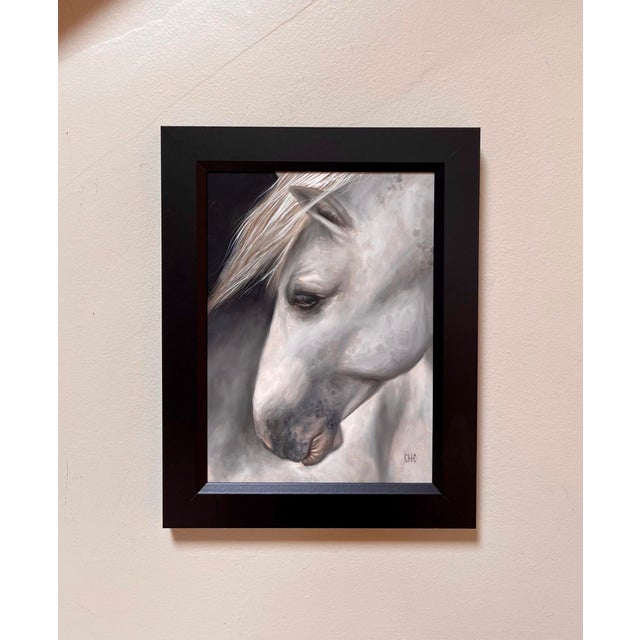 Penumbra features a close-up portrayal of a horse, its soft, flowing mane contrasting against a dark background. The...