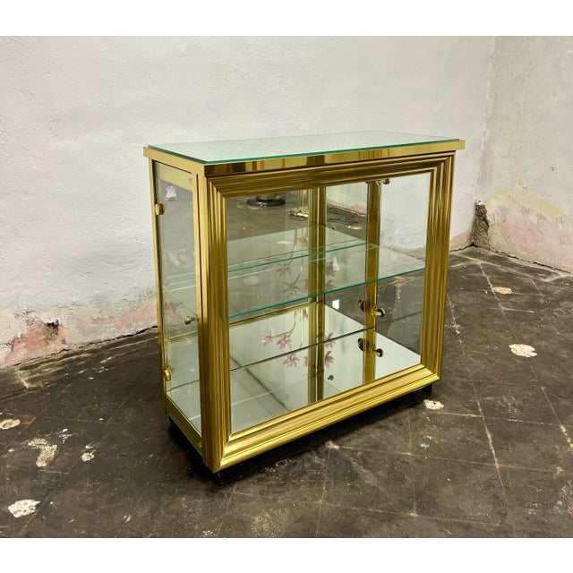 A sleek & modern display cabinet from Italy circa 1970s. It features mirrored top, bottom and back with glass doors on...