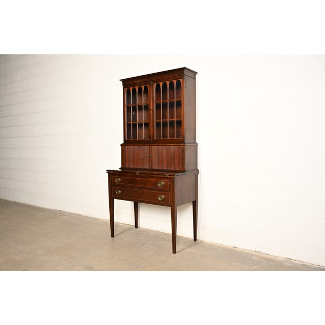 An exceptional Hepplewhite or Federal style tambour door secretary desk with bookcase hutch In the manner of Baker...