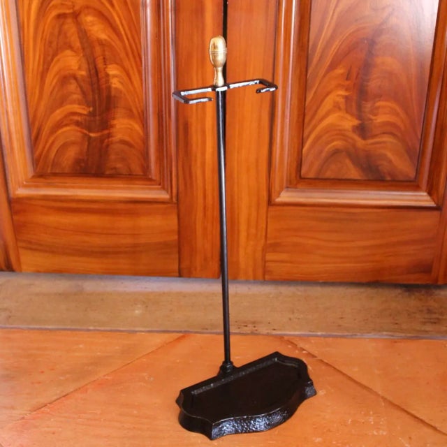 A heavy cast iron fire tool holder with a serpentine contoured base, the inside of which is recessed and finished in a...