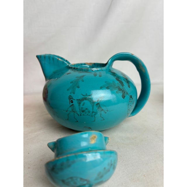 One turquoise Cierro Orvieto teapot made by Ilario Ciaurro. This lovely teapot is adorned with black semi-sheer depictions...