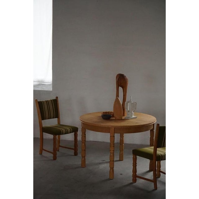 Classic round dining table in solid oak, crafted by a Danish cabinetmaker in the 1960s – reminiscent of the sculptural...