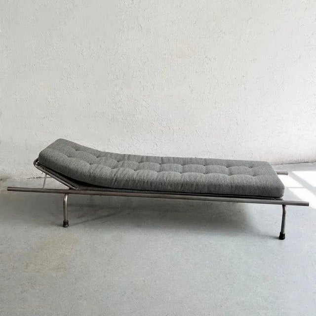 Industrial, tubular steel frame, chaise longue with newly upholstered chenille cushion with leather buttons.