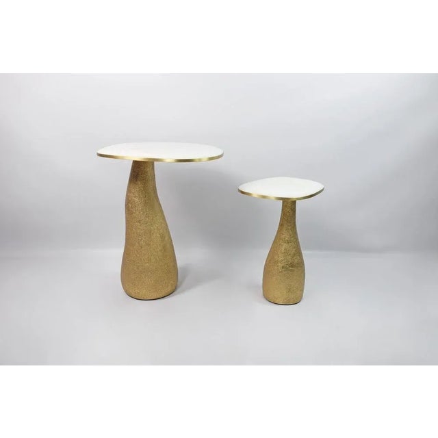 This set of 2 tables is made of a white rock crystal marquetry top with brass trims. The base is made of wood with a...