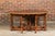 A rustic English pine drop-leaf table from the 19th century with oval top, turned swivel legs, two lateral dovetail...
