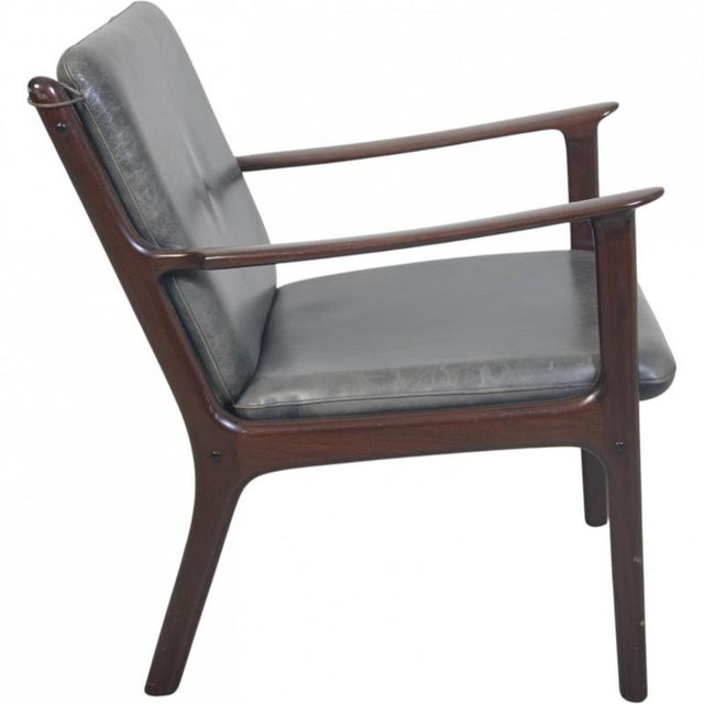 Ole wanscher pj112 chair upholstered with black anilin leather and with a frame of lacquered mahogany. The chair is from...