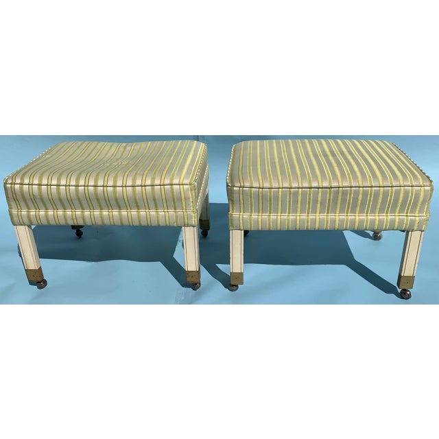 1960s Mid century style ottomans, upholstered in striped yellow cotton blend fabric. With antique brass casters and...