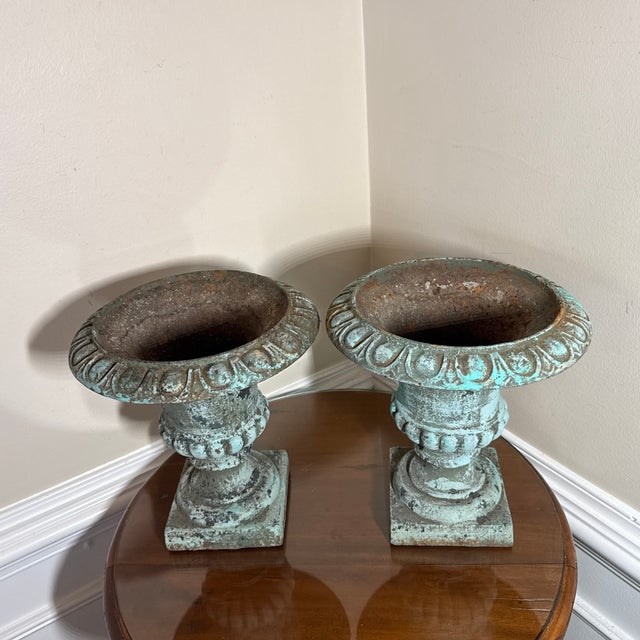 stunning vintage pair of French Country-style cast iron garden urn planters. Featuring a beautifully aged verdigris green...