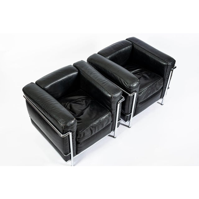 This matching set of four authentic LC2 Petit Modele black leather armchairs originally designed by Le Corbusier,...