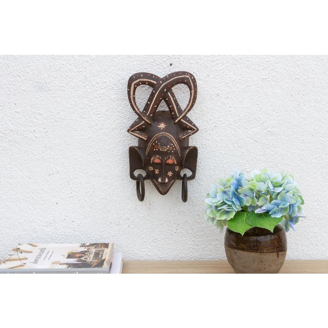 This striking mask, with its bold geometric patterns and avian-inspired design, speaks of a rich cultural heritage and...